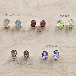 Peut inclure: Un ensemble de 10 boucles d'oreilles ovales en pierres précieuses de différentes couleurs, notamment labradorite, grenat, péridot, améthyste et quartz fumé. Chaque boucle d'oreille est sertie d'argent.