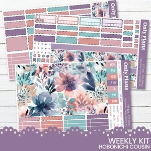 May include: A weekly planner sticker kit designed for the Hobonichi Cousin planner. The kit features a floral design with pink, blue, and purple flowers on a white background. The stickers include boxes, banners, and a variety of other shapes and sizes.