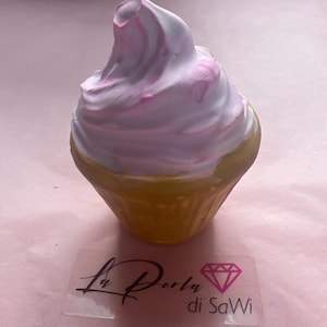 Könnte beinhalten: Ein dekoratives Objekt in Cupcake-Form mit gelbem Boden und einer Wirbel aus weißem und rosa Zuckerguss. Das Objekt hat ein klares Etikett mit dem Text "La Perla di SaWi" und einer Diamantgrafik.