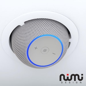 Puede incluir: Un moderno altavoz de techo empotrado con un exterior de malla gris y un panel de control circular. El panel presenta controles de volumen y encendido, iluminados por una luz azul. El altavoz está colocado en un marco circular blanco.
