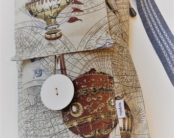 Pode incluir: Uma bolsa de tapete de ioga bege com estampa de mapa mundi e desenhos de balões de ar quente. A bolsa tem um bolso grande na frente com fecho de botão e um bolso menor com uma etiqueta que diz "Yoga & Via".