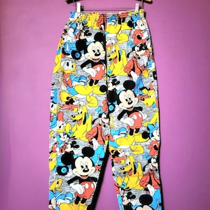 May include: Grey sweatpants with a colourful all-over print of Mickey Mouse, Donald Duck and Goofy.
