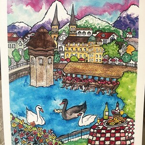 May include: Watercolor painting of a Swiss village with a bridge over a lake. The village is surrounded by mountains and there are swans swimming in the lake. There is a picnic table with a red and white checkered tablecloth, wine bottles, glasses, and cheese on a plate. The painting is signed "Dianna" and dated "7/14".