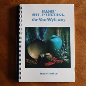 May include: A book titled "Basic Oil Painting the Van Wyk Way" by Helen Van Wyk. The cover features a still life painting of a blue vase, a bowl, and other objects on a red cloth.
