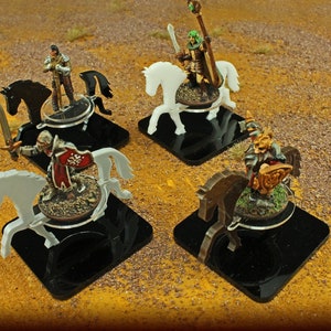 May include: Four miniature figures on horseback, each on a black square base. The figures are painted in various colors, including white, black, brown, and gold. The horses are all in different poses, and the figures are holding swords and other weapons.