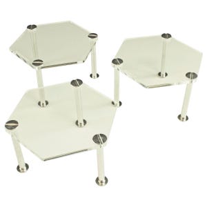 May include: Three clear acrylic hexagonal tiered display stands with silver metal legs. The stands are stacked on top of each other.