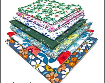 May include: A stack of ten-inch by ten-inch (25.4 cm x 25.4 cm) 100% cotton fabric squares in various floral patterns. The fabrics feature designs with white, red, blue, and orange flowers on backgrounds of green, white, and navy blue. The text "PBC8080FS / 10" X 10" 100% Cotton" is visible.