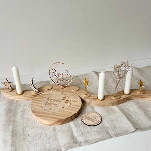 May include: Wooden Ramadan candle holder with a crescent moon, stars, and lanterns. The holder is decorated with the text "Ramadan Kareem".