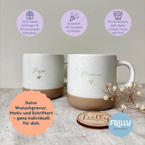 May include: Two white ceramic mugs with a speckled finish and a solid brown base. One mug features the script text Papa with a small heart, and the other features the script text Mama with a small heart. The mugs are accompanied by a wooden coaster.