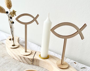 May include: Wooden Advent wreath with four candle holders, two wooden fish symbols, and a small vase for flowers. The wreath is made of natural wood and has a rustic look. The words "frilly designs" are printed on a round wooden tag.