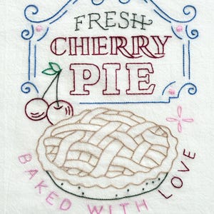 May include: Embroidered white fabric with a cherry pie design. The words "FRESH CHERRY PIE" are above the pie, and "BAKED WITH LOVE" is around the pie. The pie has a woven crust and two cherries with green leaves.