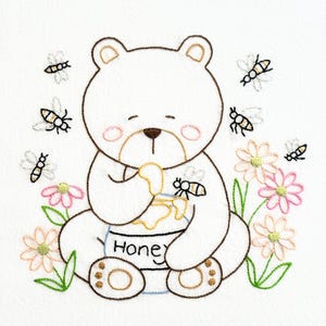 May include: An embroidery design featuring a white bear with brown outlines sitting and eating from a pot labeled Honey. The bear is surrounded by small flying bees and pink flowers with green stems. The bear has pink cheeks and brown paw pads.