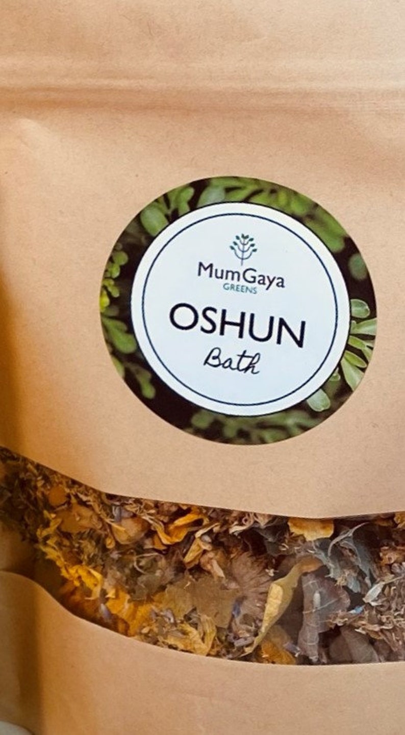 May include: A brown paper bag with a white circular sticker. The sticker features a green plant illustration and the text "MumGaya Greens" and "OSHUN Bath".