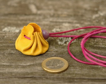 Micro leather bag (approx. 3 cm base diameter) made of yellow leather with a fuchsia-colored leather strap for hanging around the neck for rings, pendants, emergency funds