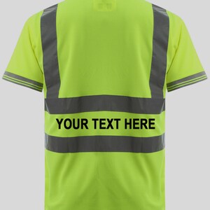 May include: A bright yellow safety polo shirt with reflective black stripes and the text "YOUR TEXT HERE" printed on the back.