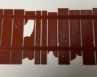 May include: A brown wooden fence with a section missing. The fence is made of vertical planks with horizontal supports. The fence is weathered and has a rustic look.