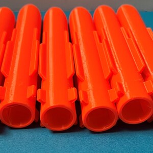 May include: Six bright orange plastic anchors with a ribbed texture and multiple slots on the sides.