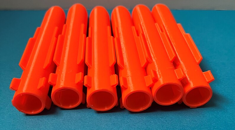 May include: Six bright orange plastic anchors with a ribbed texture and multiple slots on the sides.