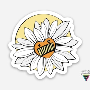 May include: A die-cut sticker featuring a white daisy flower with a heart-shaped orange center. The center has two small eyes and a wide, rectangular mouth with vertical teeth. A pale yellow circle sits behind the flower petals.
