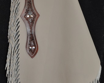 May include: A pair of light gray leather chaps with fringe detail. The chaps have a brown leather belt and a brown leather flap with decorative stitching.