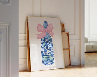 May include: A framed print of a blue and white patterned champagne bottle with a pink bow. The bottle is on a white background.