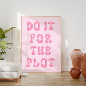 May include: A pink framed poster with the text "DO IT FOR THE PLOT" in a bubble-like font.