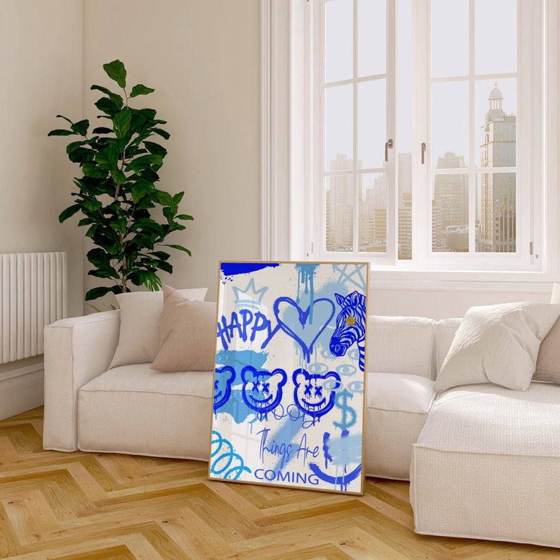 K&ouml;nnte beinhalten: Ein blauer und goldener abstrakter Kunstdruck mit einem Zebra, einem Herzen und Smiley-Gesichtern. Der Text "Happy Things Are Coming" ist in Blau und Gold geschrieben.