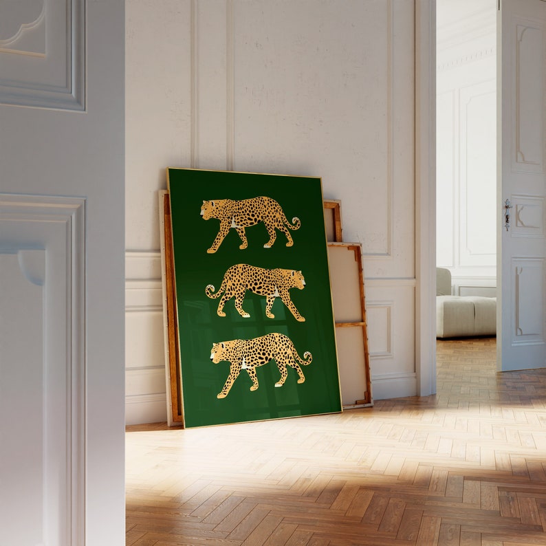 May include: A framed print with a green background and three gold leopards walking in a row. The leopards are outlined in gold and have a black spot pattern.