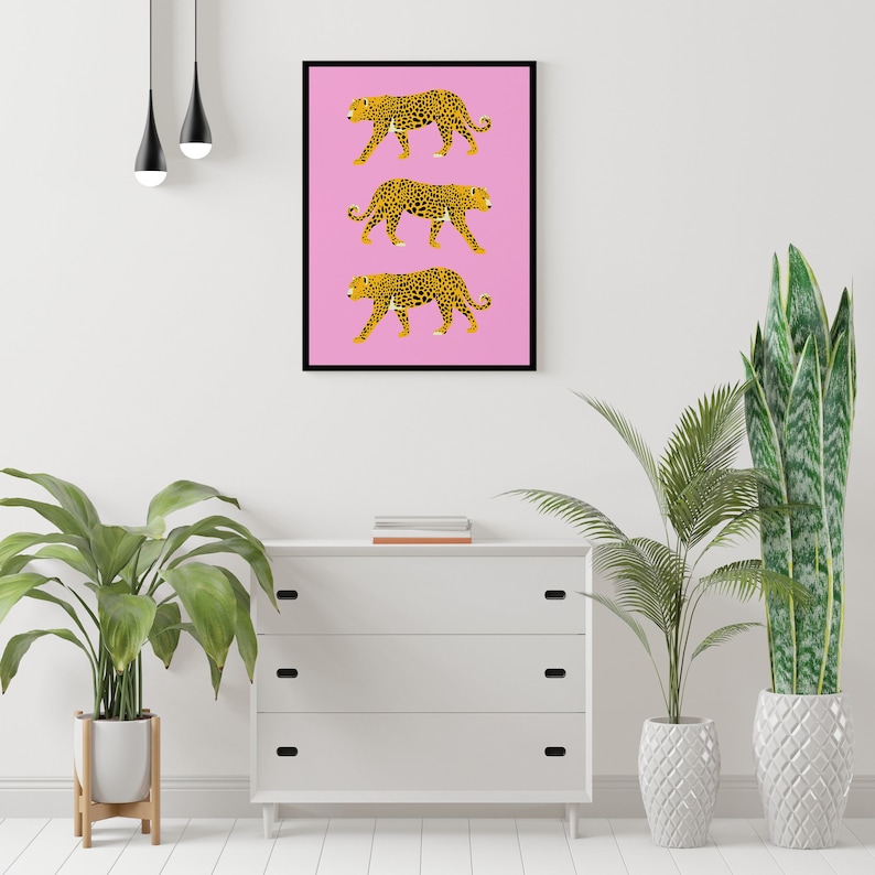 Op de afbeelding: Een roze achtergrond met drie zwarte en gele luipaardprint illustraties die in een rij lopen.