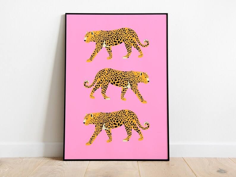 Op de afbeelding: Drie gele en zwarte luipaardprint illustraties op een roze achtergrond. De luipaarden lopen in een rij, met hun gezicht naar de rechterkant van de afbeelding.