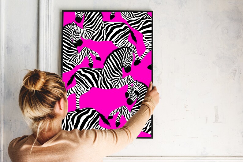 May include: A framed print with a pink background and a black and white zebra pattern. The zebra pattern is repeated throughout the print.