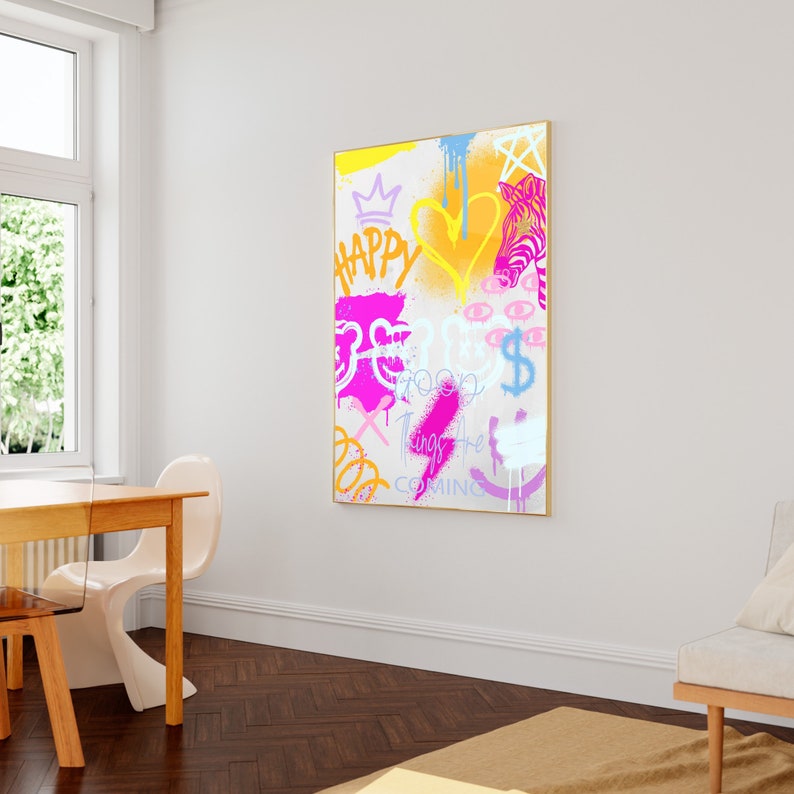 K&ouml;nnte beinhalten: Ein farbenfrohes abstraktes Gem&auml;lde mit wei&szlig;em Hintergrund und goldenem Rahmen. Das Gem&auml;lde zeigt verschiedene Formen, darunter Herzen, Sterne und Augen. Der Text "Happy Things Are Coming" ist in rosa und lila Buchstaben geschrieben.
