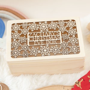 May include: A wooden Christmas Eve box with a snowflake design and the text "Zachary's Christmas Eve Box" on the lid.