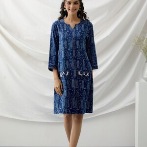 May include: A blue and white printed cotton dress with a V-neckline and three-quarter sleeves. The dress has a pocket on each side with pearl embellishments.