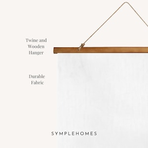 May include: A white fabric wall hanging with a wooden hanger and twine. The text "Twine and Wooden Hanger" and "Durable Fabric" are visible. The brand name "SYMPLEHOMES" is printed at the bottom.