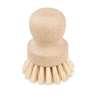 Könnte beinhalten: Eine Bürste aus Holz mit Naturborsten. Die Bürste hat einen runden Holzgriff.