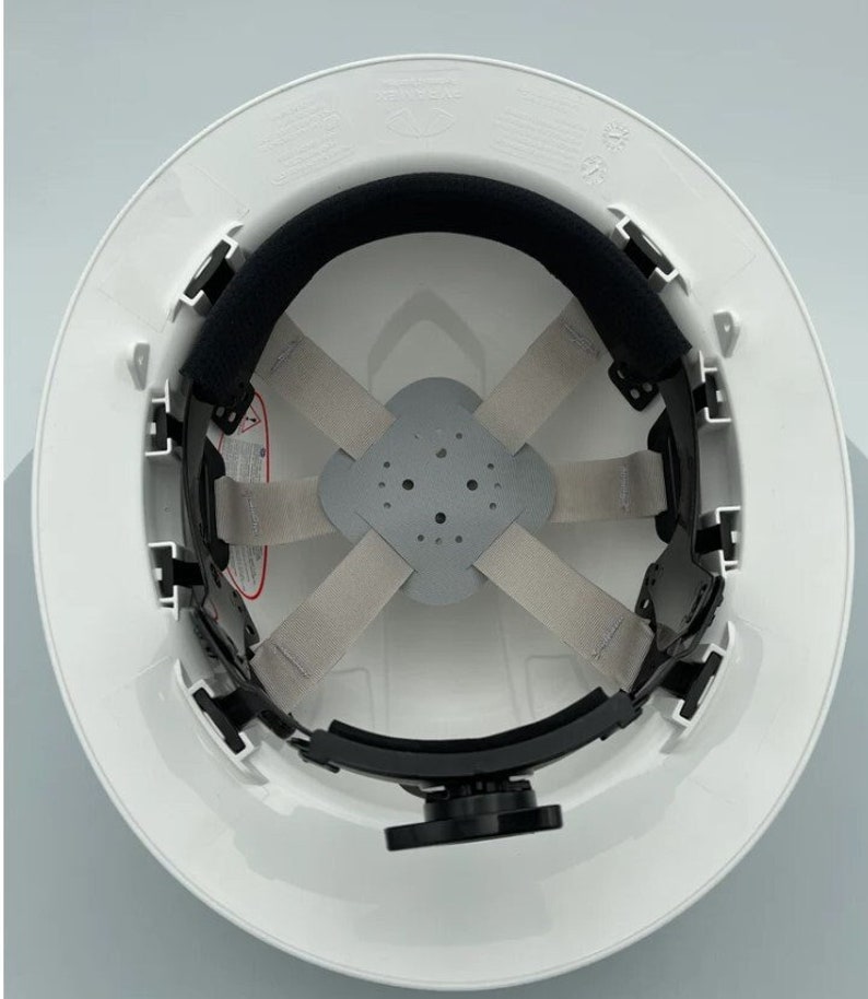 May include: White hard hat with a black suspension system and a black chin strap. The suspension system has a gray webbing and a gray pad.