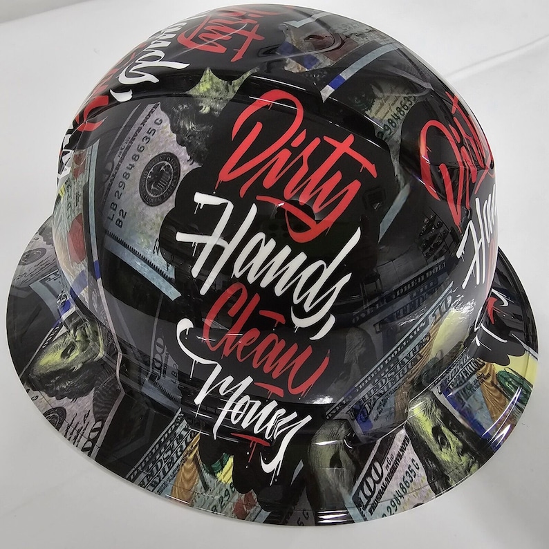 May include: Black hard hat with a graphic design of dollar bills and the text "Dirty Hands Clean Money".