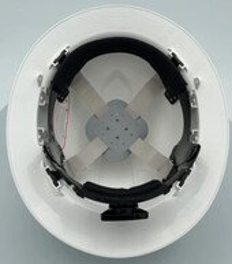May include: White hard hat with a black suspension system and a white chin strap. The hard hat has a textured surface.