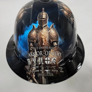 May include: A black hard hat with a graphic of a knight in armor. The graphic includes the text "Put on the full armor of God" and "Ephesians 6:10".