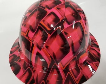 May include: A pink hard hat with a black and orange geometric pattern. The hat has a brim and a hard shell.