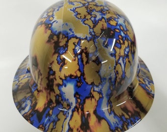 May include: A hard hat with a blue and gold camouflage pattern. The hat has a smooth, glossy finish.