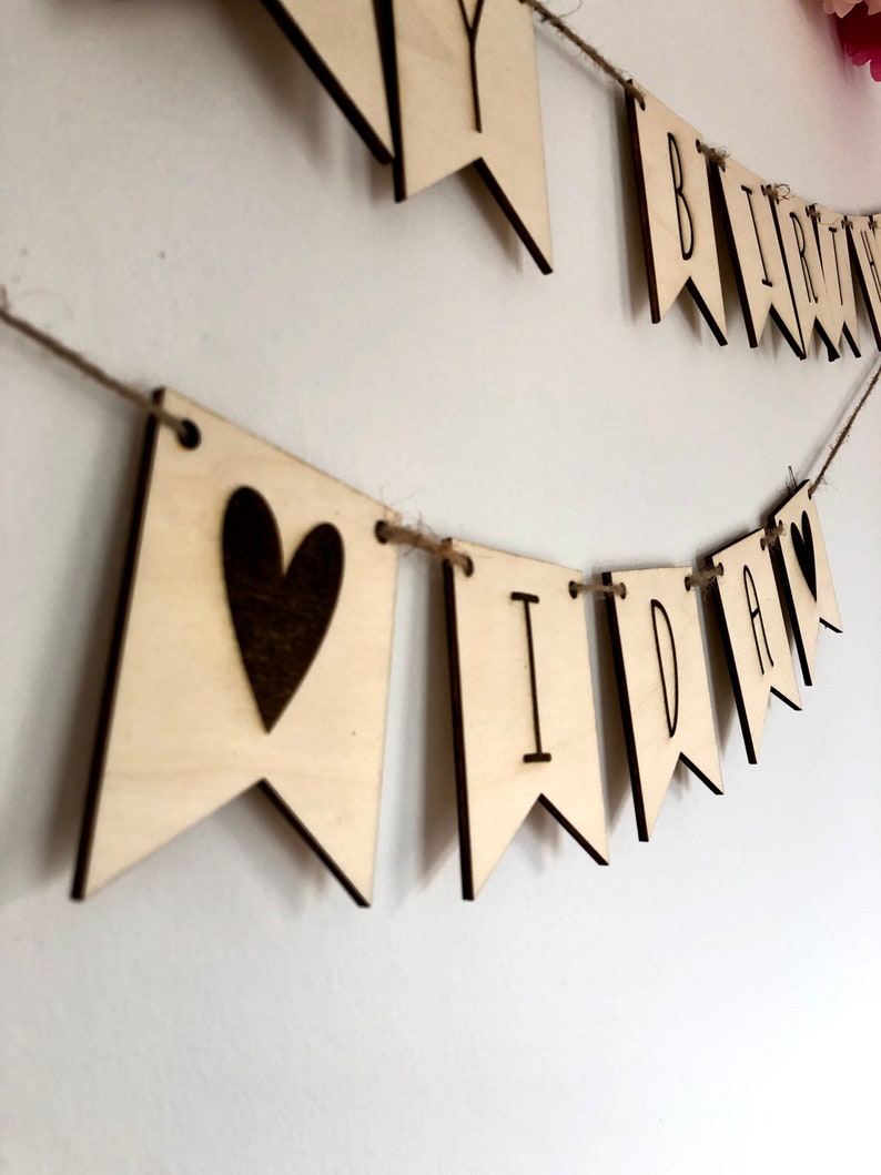 Happy Birthday Wimpelkette aus Pappelholz mit gravierten Buchstaben. Buchstaben auf Juteband aufgezogen. Personalisierter Schriftzug mit gravierten Herzen