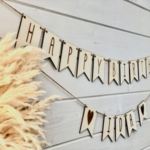 Happy Birthday Wimpelkette aus Pappelholz mit gravierten Buchstaben. Buchstaben auf Juteband aufgezogen. Personalisierter Schriftzug mit gravierten Herzen