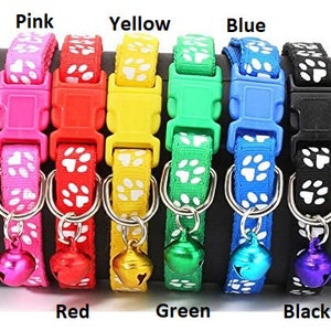 May include: A set of eight colourful cat collars with paw print designs and a bell. The collars are available in pink, red, yellow, green, blue, and black.