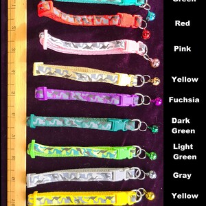 May include: A set of 10 camouflage cat collars with different coloured trim and a bell on each. The colours are green, red, pink, yellow, fuchsia, dark green, light green, grey, yellow, and blue.