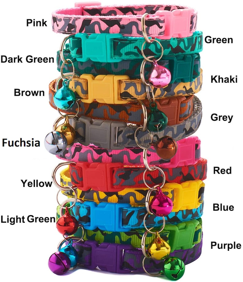 May include: A stack of ten colourful cat collars with a camouflage pattern and a bell on each collar. The collars are in the following colours: pink, dark green, brown, fuchsia, green, khaki, grey, yellow, red, light green, blue, and purple.
