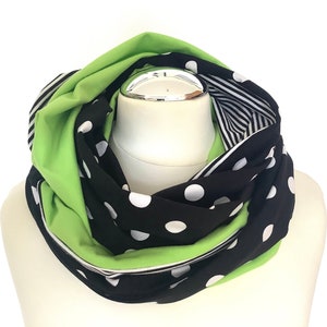 Könnte beinhalten: Ein schwarzer und grüner Infinity-Schal mit weißen Punkten und einem schwarz-weiß gestreiften Muster.