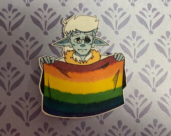 May include: A sticker featuring a cartoon character with blue skin, holding a rainbow flag. The character has white hair, pointed ears, and is wearing glasses. The flag has stripes of red, orange, yellow, green, blue, and purple.