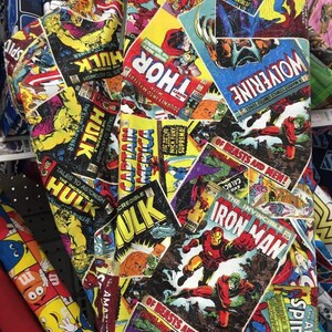 May include: A colorful fabric featuring a collage of vintage comic book covers featuring Marvel superheroes like Captain America, Thor, Hulk, Wolverine, Iron Man, and Spider-Man. The fabric is a mix of red, yellow, blue, green, and black.